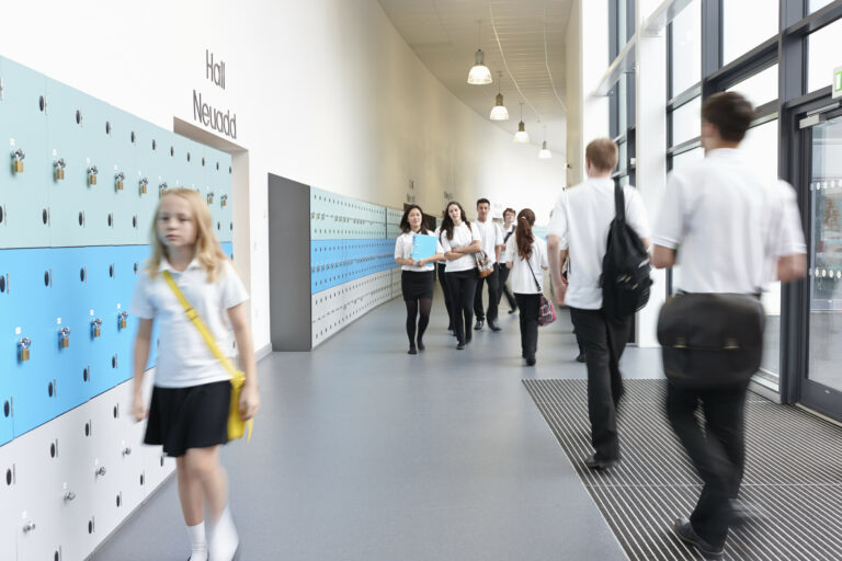 Unhappy schoolgirl walking in school corridor