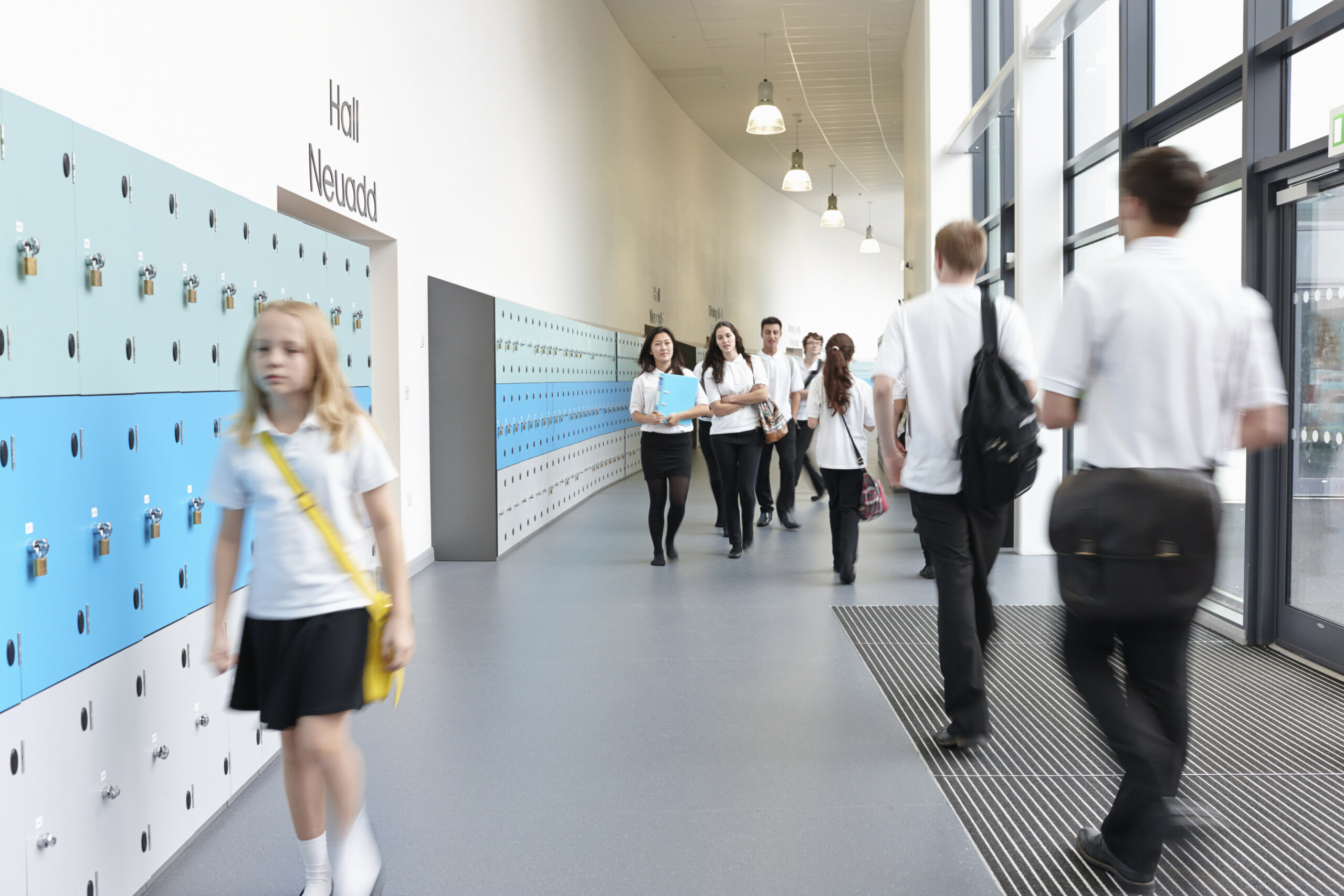 Unhappy schoolgirl walking in school corridor